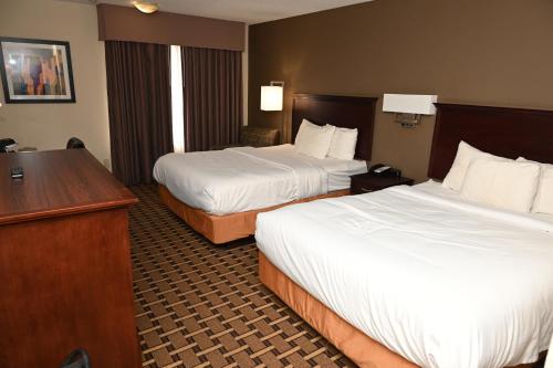 a hotel room with two beds and a desk at Savai Hotel in Overland Park