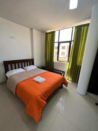a bedroom with a large bed with green curtains at HOTEL PUNTA PARIÑAS-TALARA-PERU in Talara