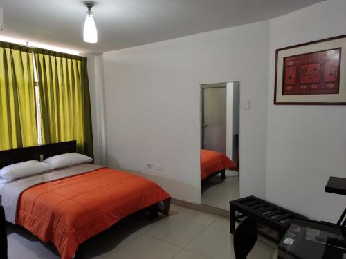 a bedroom with a bed and a yellow curtain at HOTEL PUNTA PARIÑAS-TALARA-PERU in Talara