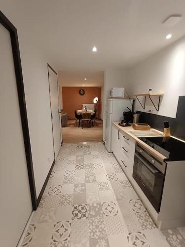 une cuisine avec un comptoir et une table en arrière-plan dans l'établissement Bnbujaret, à Saint-Chamond