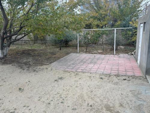 un filet de volley-ball dans une cour avec un arbre dans l'établissement Vilage, à Soumgaït