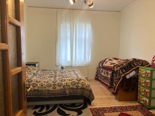 - une chambre avec 2 lits et une fenêtre dans l'établissement Vilage, à Soumgaït