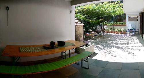 a room with a wooden table and a view of a yard at Apartments Stinice in Gradac