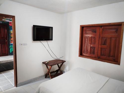 a bedroom with a bed and a television on a wall at Divino Niño Hotel in Leticia