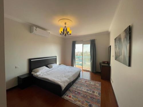 Schlafzimmer mit einem Bett und einem Kronleuchter in der Unterkunft Fun Beach - Durrat AL Arous in Durrat Al-Arus