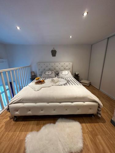 - une chambre avec un lit blanc et un tapis blanc dans l'établissement Duplex cosy bord de Mer, à Saint-Cyr-sur-Mer