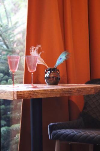 dois copos e um vaso numa mesa em Tiny House in de Boomgaard em Stad aan ʼt Haringvliet