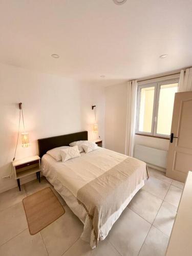 - une chambre blanche avec un grand lit et une fenêtre dans l'établissement Les Bords de l'Estaque x Le refuge de Cézanne, à Marseille