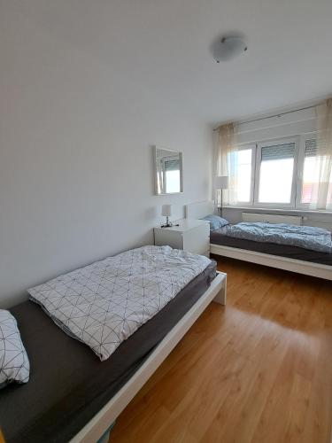 a bedroom with two beds and two windows at Charming Celje City Center Apartment in Celje