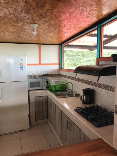 cocina con nevera blanca y fregadero en Reserva Natural Finca La Cabaña, en Dosquebradas
