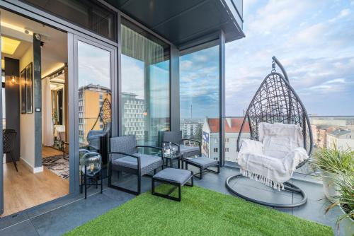 a balcony with a swing and a table and chairs at Q18 ApartHotel in Bydgoszcz