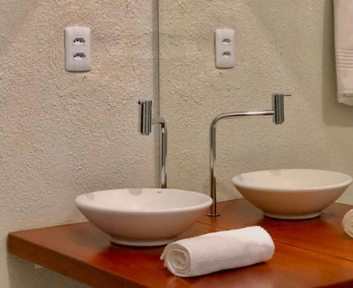 ein Badezimmer mit zwei weißen Schalen auf einer Theke in der Unterkunft Pousada Jardins in Santarém