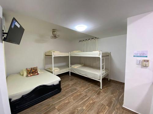 a room with two bunk beds and a tv at Casa ISABELLA - Playa dormida in Santa Marta