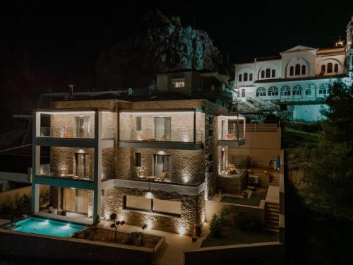 a villa with a swimming pool at night at Fildisi luxury suites in Nafplio