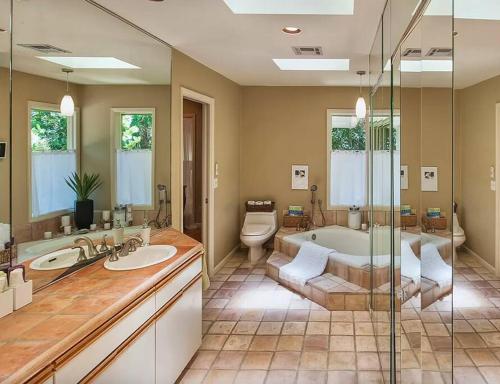 a bathroom with two sinks and a tub and a toilet at Beach Paradise Getaway - 200ft from Beach! in Sebastian