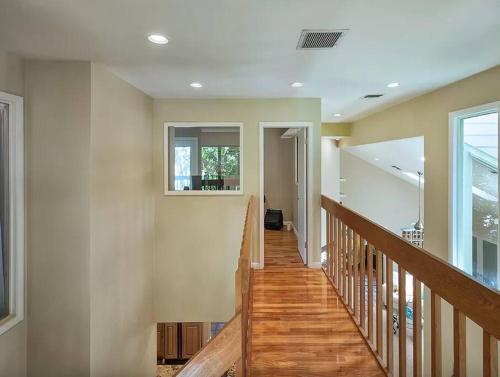 a hallway with a wooden staircase with a window at Beach Paradise Getaway - 200ft from Beach! in Sebastian