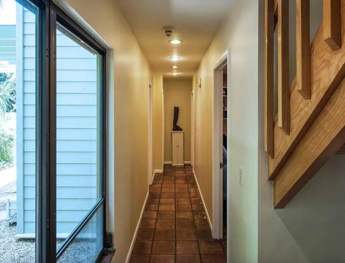 a hallway of a house with a staircase and a window at Beach Paradise Getaway - 200ft from Beach! in Sebastian