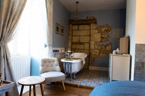une salle de bain avec une baignoire et un lavabo dans l'établissement Logis de Tirac, à Lorignac