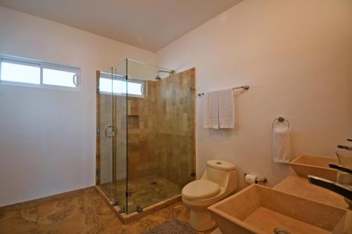 a bathroom with a shower and a toilet and a sink at Oceanview Living Space & Balcony with FiberOptic WiFi! in La Paz