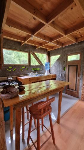 a kitchen with a wooden table and a wooden chair at Cabaña Solar del Maipo in San José de Maipo