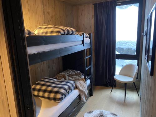two bunk beds in a room with a window at Kikut Alpin Lodge Ski in - Ski out in Geilo