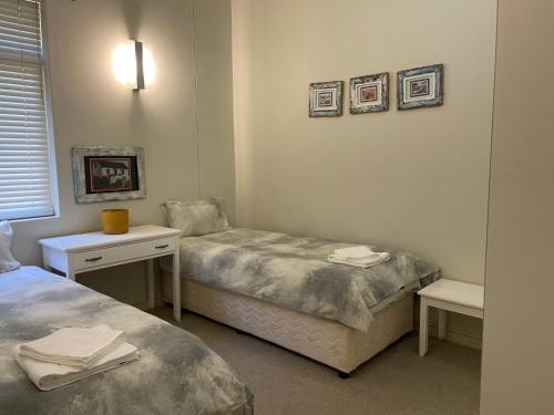 a room with two beds and a table and a desk at The Herolds Bay 611 in Herolds Bay
