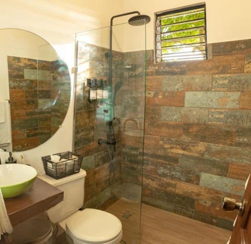 a bathroom with a toilet and a glass shower at Rincones del Mogote 