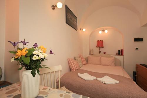 a bedroom with a bed and a vase of flowers at Apartment in the heart of Ljubljana in Ljubljana