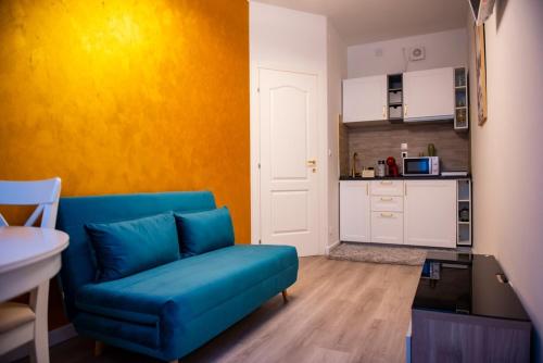 a living room with a blue couch and a kitchen at Isabel Apartaments Old Town in Padova