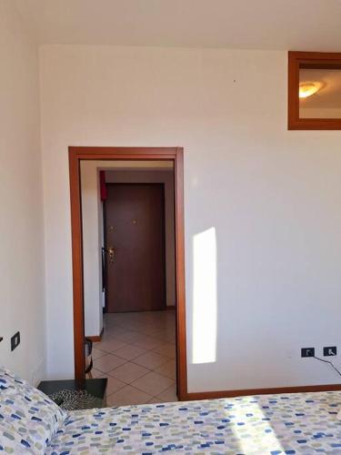 a bedroom with a bed and a door to a hallway at Casa Vacanza da Franco in Cremona