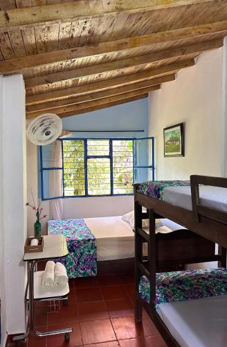 a bedroom with two bunk beds and a window at Cabaña-Finca Portal De La Ceiba in San Gil