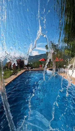 a pool with water splashing in the air at Cabaña-Finca Portal De La Ceiba in San Gil