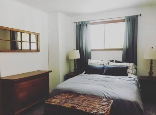 Un dormitorio con una cama grande y una ventana en Peaceful lakeside cottage great for a staycation., en Dwight