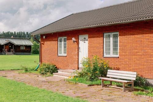 Bonäs bygdegård في مورا: منزل من الطوب ومقعد أمامه