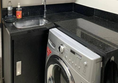 cocina con fregadero y lavadora en Apartamento na quadra da praia en Río de Janeiro