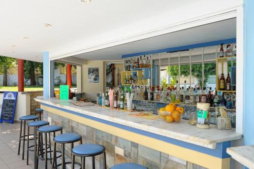 un bar avec des tabourets bleus devant dans l'établissement Melissa Apartments, Studios & Suites, à Mália