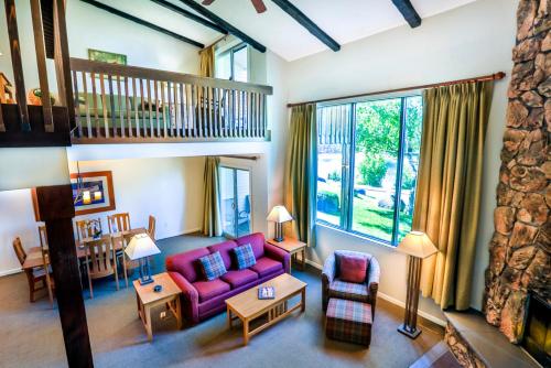 uma sala de estar com um sofá roxo e uma grande janela em Lake Placid Club Lodges em Lake Placid