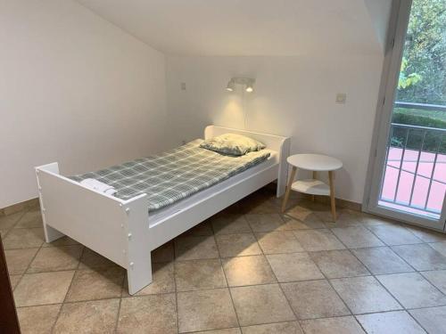a white bed in a room with a window at Villa 13 in Étrembières