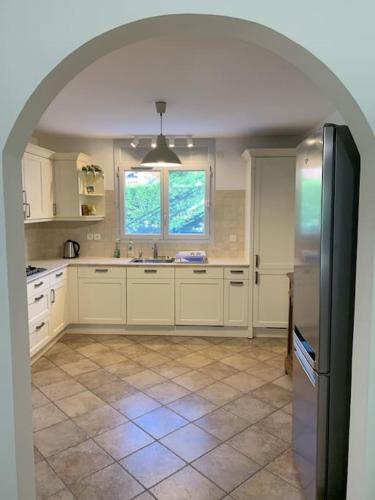 a kitchen with white cabinets and a refrigerator at Villa 13 in Étrembières