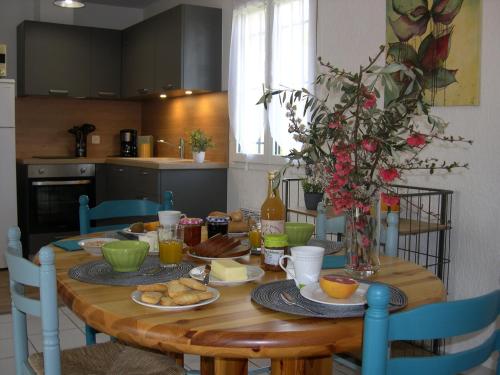 - une table en bois avec de la nourriture dans la cuisine dans l'établissement Gîtes Terre d'Avens, à Chauzon