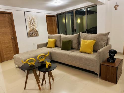 ein Wohnzimmer mit einem Sofa und 2 Tischen mit gelben Kissen in der Unterkunft - Casa Blanca - in Ocotlán