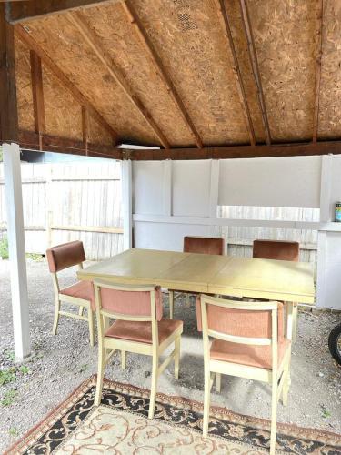 漢密爾頓的住宿－Bonito lugar para descansar，一张桌子和椅子坐在屋顶下