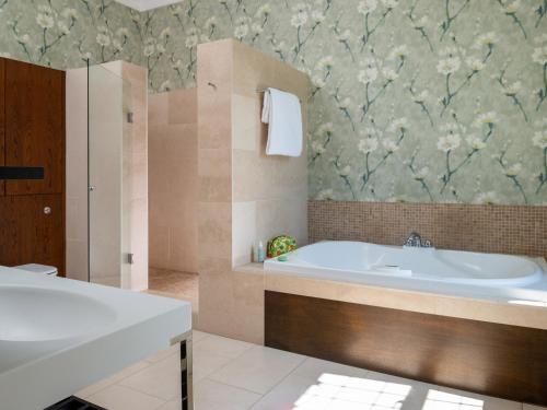 een badkamer met een bad en een wastafel bij Moorlands Manor in Colne