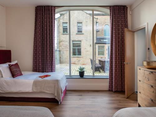 ein Schlafzimmer mit einem Bett und einem großen Fenster in der Unterkunft Moorlands Manor in Colne