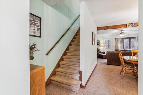 a staircase leading up to a living room and dining room at Two bedroom Townhouse within walking distance to all activities Glazebrook J4 in Killington