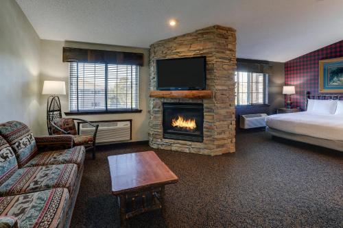 Habitación de hotel con chimenea y cama en Stoney Creek Hotel Des Moines - Johnston en Johnston