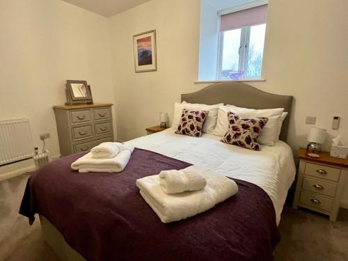 a bedroom with a large bed with towels on it at 29 Malthouse Alnwick Holiday Apartment in Alnwick
