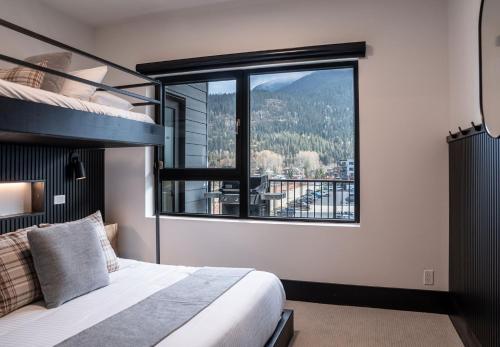 1 dormitorio con cama y ventana grande en Altitude Adjustment by Revelstoke Vacations, en Revelstoke