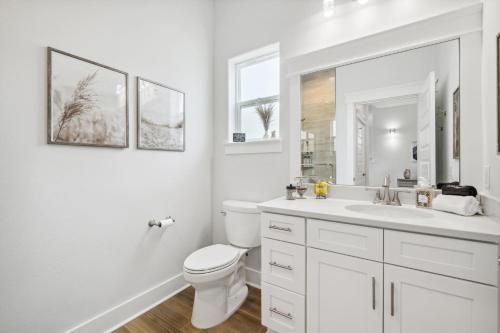 a white bathroom with a toilet and a sink at Emerald Oasis at Laguna Haven in Panama City Beach