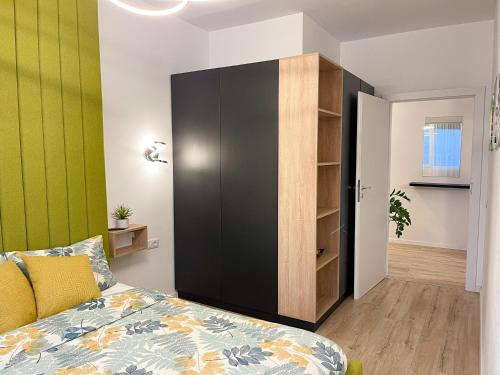una camera da letto con un grande armadio nero e un letto di Emerald Apartment a Arad